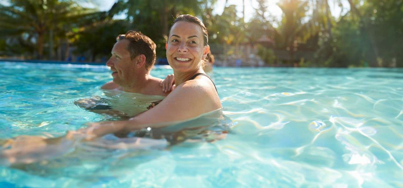 An adult couple swimming in the Subtropical Swimming Paradise.