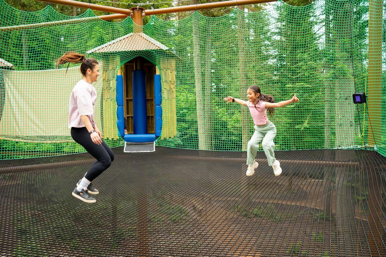 A girl and her mum jumping up and down on the Adventure Nets.