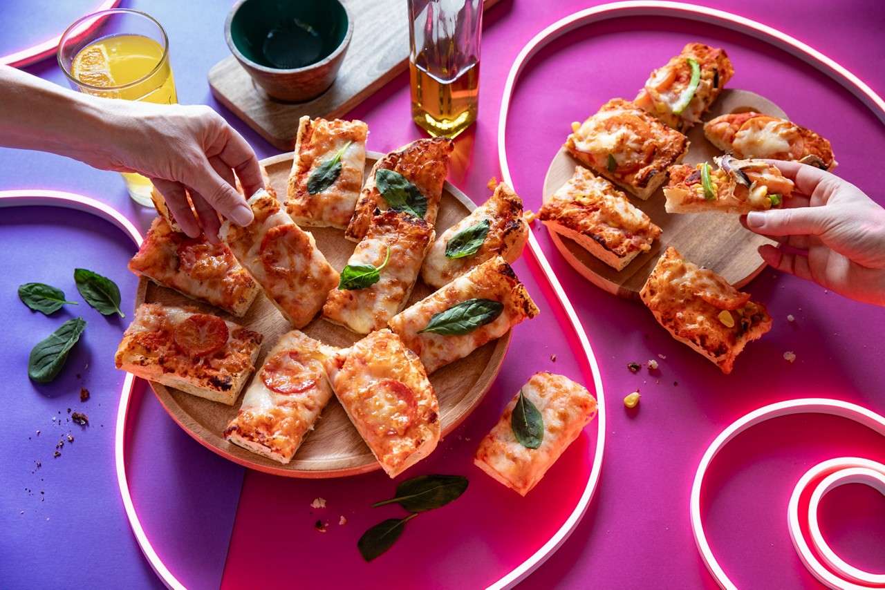 Pizza squares topped with fresh basil.