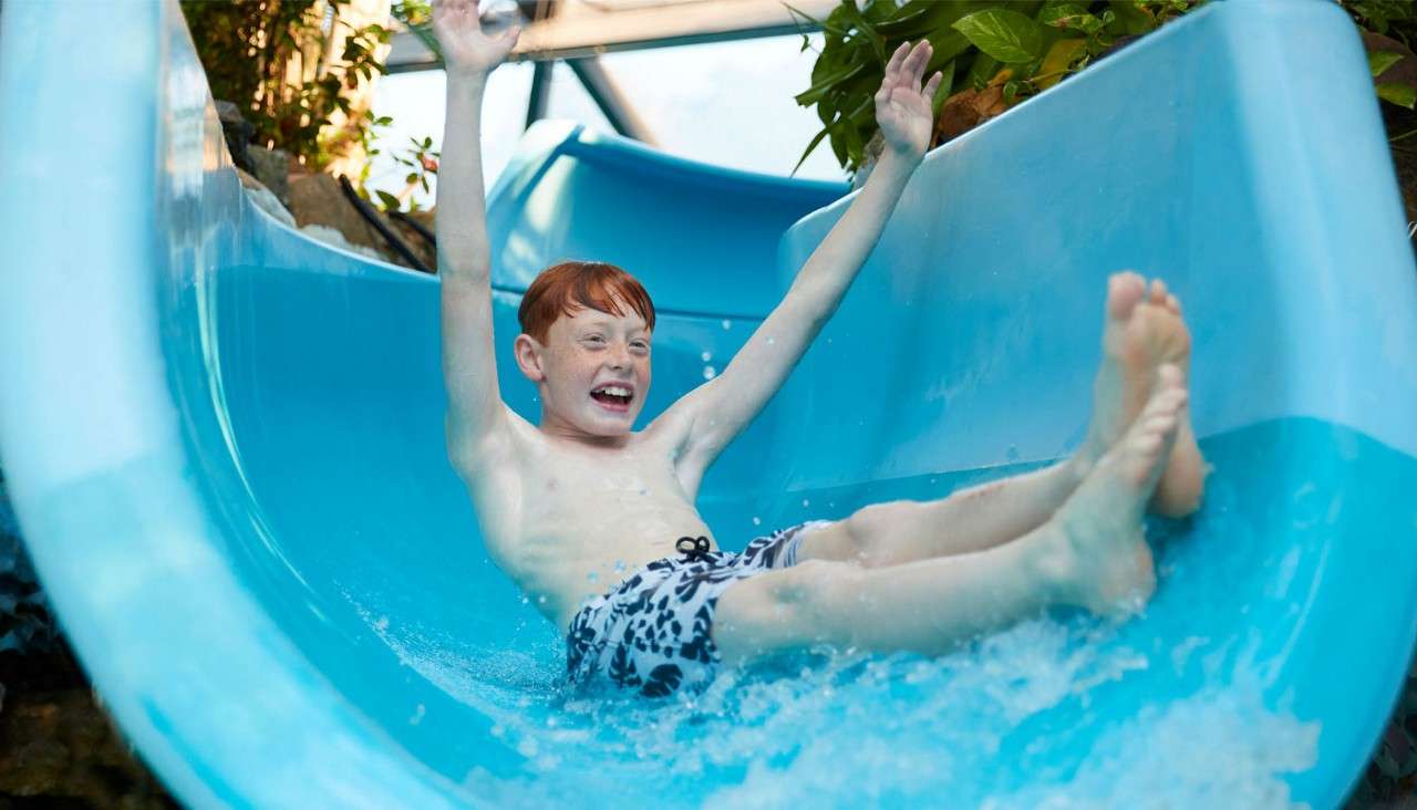 A boy going down the slides in The Subtropical Swimming Paradise.