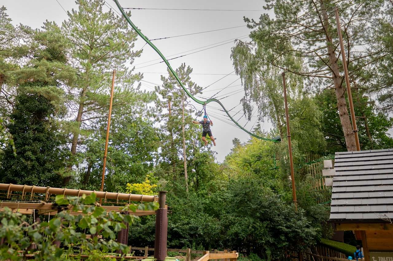 Man gliding across the Treetop Glider.