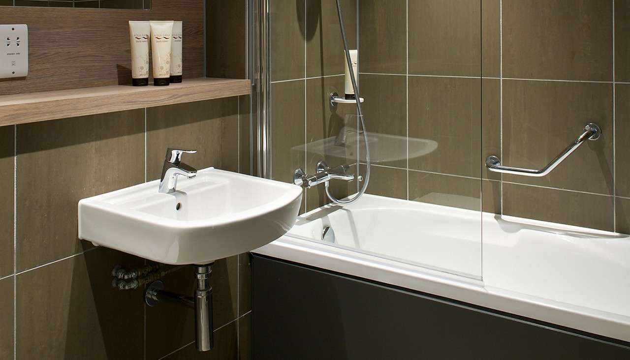 A bathtub and sink in the bathroom of an Forest Lodge