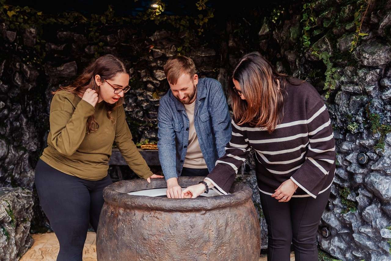 A group looking into a steaming cauldron.