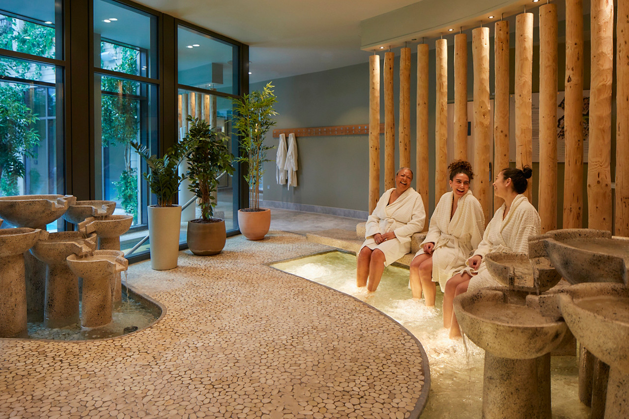 Three ladies with their feet in hot whirpools. 