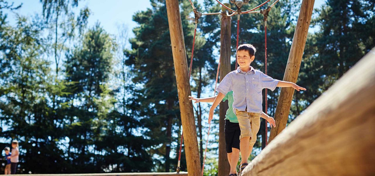 A boy playing on an adventure playground
